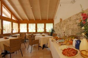 a restaurant with tables and chairs with food on them at Agriturismo Maso Grener in Lavis