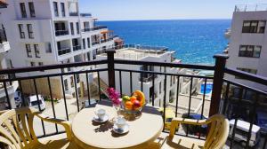 een tafel met een fruitschaal op een balkon met uitzicht op de oceaan bij Комплекс Бяла Виста до Плажа - Complex Byala Vista near the beach in Byala