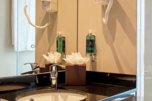 a bathroom with a sink and a mirror at Vila Galé Estoril in Estoril