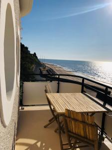 a wooden table and chair on a balcony overlooking the ocean at Le Paquebot in Villerville