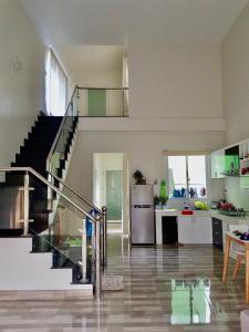 a kitchen with a staircase and a kitchen with a table at Nhiên Homestay - The Green House in Phú Quốc