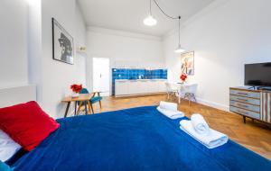 een slaapkamer met een blauw bed en handdoeken bij 2BCOMFY - Nad Niprem in Bielsko-Biala