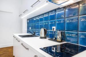 a kitchen with blue tiles on the wall at 2BCOMFY - Nad Niprem in Bielsko-Biała