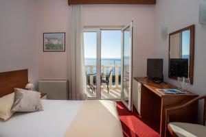 a hotel room with a bed and a view of the ocean at Hotel Neva in Podstrana