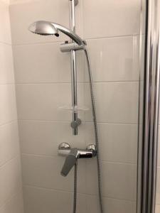 La salle de bains est pourvue d'une douche avec un pommeau de douche. dans l'établissement Hôtel & Résidence Sarcelles, à Sarcelles