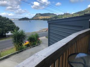 a wooden fence with a view of a body of water at Taurikura Bay Relax and Explore in Whangarei Heads