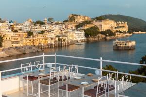 a balcony of a boat with a table and chairs at Hanuman Ghat Boutique Stays by Cafe Helsinki in Udaipur