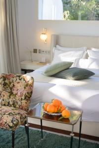 a bedroom with a bed with a chair and a tray of oranges at Maison Dedine- SmallLuxuryHotels -Adults Only in Sidi Bou Saïd