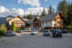 a parking lot with cars parked in front of buildings at Art Hotel Kristal in Bohinj