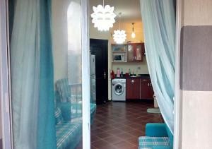 a kitchen with a view of a living room with blue curtains at شاليهات بورتو مطروح فيو بحر Porto Matrouh Sea View Families Only in Marsa Matruh