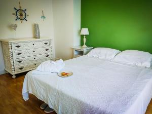 a bedroom with a white bed with a plate of fruit on it at Cabanas Terraces - Pool and seaview in Tavira