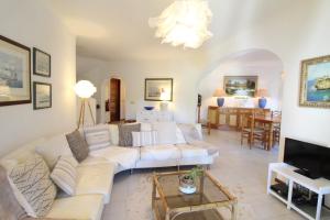 a living room with a white couch and a tv at Typical Portuguese Beach House just 88m to the beach in Porches