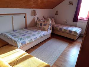 two twin beds in a room with wooden floors at Miklai Ház in Szigliget