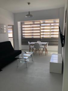 un soggiorno con un divano e un tavolo di APARTAMENTO CENTRAL 1 a Corralejo Altre 2 foto