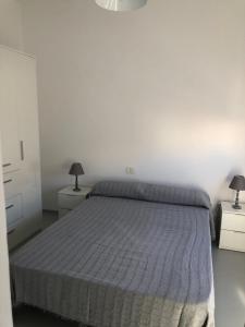 una camera da letto con un letto con due comodini e due lampade di APARTAMENTO CENTRAL 1 a Corralejo