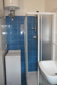 リド・ディ・イエゾロにあるVillaggio Solveig Family Apartmentsの青いタイル張りのバスルーム(シンク、シャワー付)