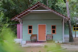 a small house with a pink door and two chairs at Commune18 in Chikmagalūr
