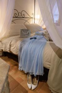 Schlafzimmer mit einem Bett mit blauem Kleid in der Unterkunft Hortus Conclusus + free parking in Siena