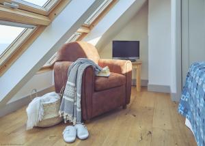 a living room with a brown chair and a tv at Craster Reach in Craster