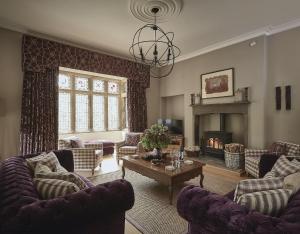 a living room with couches and a fireplace at Oughtershaw Hall in Beckermonds