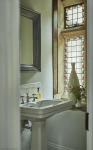a bathroom with a sink and a mirror and a window at Oughtershaw Hall in Beckermonds