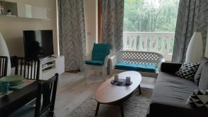 RELAX Apartment in Varna South Bay Residence في مدينة فارنا: غرفة معيشة مع أريكة وطاولة