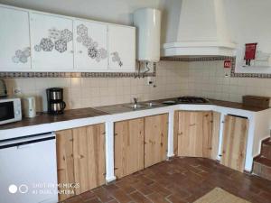 a kitchen with wooden cabinets and a sink at Casa do Castelo - Zona Histórica in Mértola