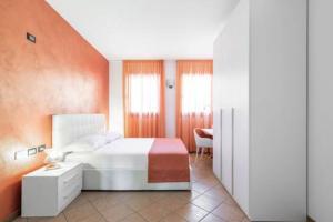 a bedroom with a white bed and an orange wall at Lake Como Golf Hotel in Como