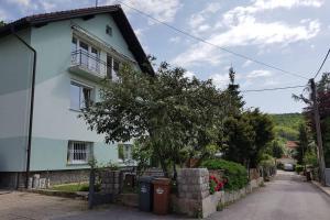 Una casa blanca con un árbol delante. en Welcome to enjoy Maribor ! en Maribor