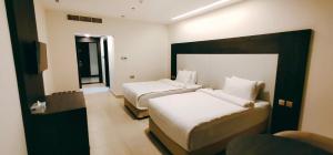 pokój hotelowy z dwoma łóżkami i oknem w obiekcie Manazil Aldar Hotel w mieście Suhar