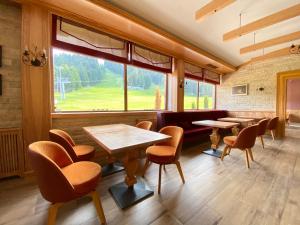 a restaurant with tables and chairs and a large window at Ice Angels Hotel in Borovets