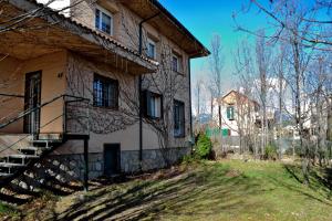 una casa antigua con escaleras al lado de un edificio en Casa Rural El Trepador Azul Futbolín Barbacoa 8 personas en Becerril de la Sierra