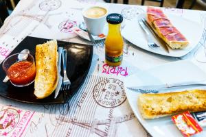 une table avec une assiette de pain et un sandwich dans l'établissement Hostal Frasca by Vivere Stays, à Ciudad Real