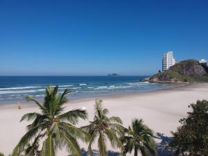 a beach with palm trees and the ocean at Hotel Ilhas da Grécia in Guarujá
