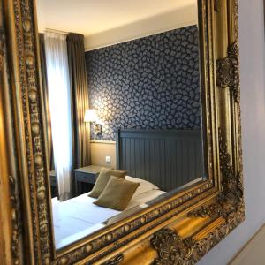 a bathroom with a large mirror and a large mirror hanging on the wall at Hotel Ajoncs d'Or in Saint Malo