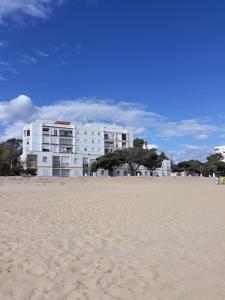a building on the beach next to a sandy beach at Loft en primera línea de playa in Isla Cristina