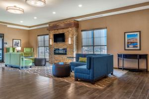 a lobby with blue chairs and a fireplace at Comfort Suites Camp Hill-Harrisburg West in Harrisburg