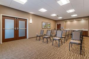 Comfort Suites Camp Hill-Harrisburg West في هاريسبورغ: قاعة اجتماعات فيها كراسي ومنضدة