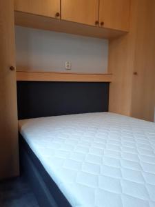 a bedroom with a white bed in a room at krabbenkreek 2 in Sint Annaland