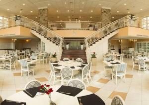 un restaurante con mesas y sillas y una escalera en Il Campanario - Vista Para a Piscina, en Florianópolis
