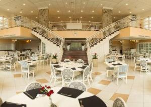 a restaurant with tables and chairs and a staircase at Il Campanario - Vista Para a Piscina in Florianópolis