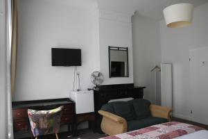 a living room with a couch and a television at Hotel Verdi in Amsterdam
