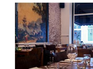 a dining room with tables and chairs and a painting on the wall at Zala's B&B in Utrecht +39 photos