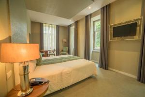 um quarto de hotel com uma cama e uma televisão em Hotel do Parque em Braga