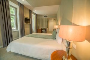 a hotel room with a bed and a lamp at Hotel do Parque in Braga