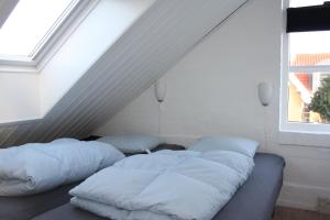 two beds in a white room with a window at Holiday-Skagen in Skagen