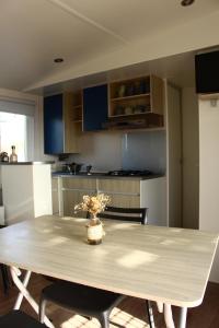 a kitchen with a table with a vase of flowers on it at Camping Les Bois Flottés in Salin-de-Giraud