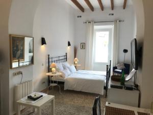 a bedroom with a bed and a table and a television at Can Mavi - Apartamentos - TI37 in Sencelles