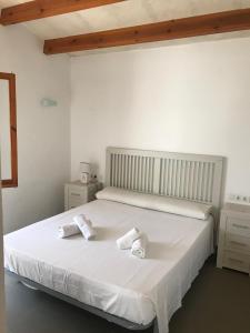 una camera da letto con un letto bianco e asciugamani di SOLMAR MENORCACOM 19 a Cala'n Bosch