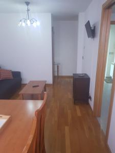 sala de estar con sofá y mesa en Apartamentos Burela, en Burela de Cabo